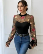 Model wearing a black floral lace embroidered bodysuit paired with blue jeans