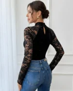 Back view of a black high neck long sleeve lace bodysuit styled with blue jeans
