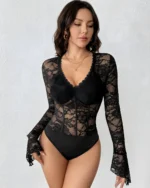 Front view of a model wearing a black lace and mesh bodysuit with sheer long sleeves and a V-neck