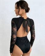 Back view of a black lace backless bodysuit showing the open back and black bow tie detail