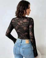Back view of a black lace and mesh bodysuit paired with blue jeans