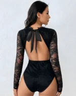Back view of a black lace open back bodysuit showing the feminine bow tie detail