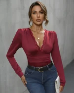Front view of a red V-neck lace bodysuit styled with blue jeans
