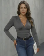 Woman wearing grey lace trimmed bodysuit with blue jeans as a going out top