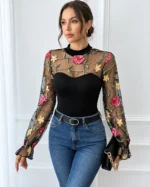 Model wearing a black floral lace embroidered bodysuit paired with blue jeans